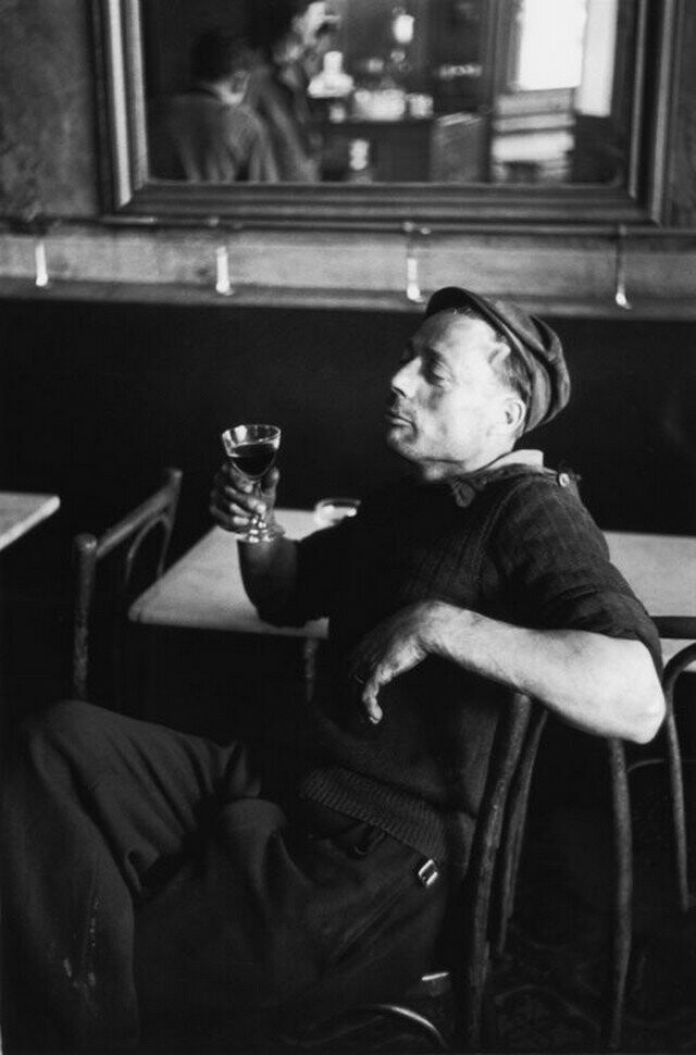 Рабочий смакует бокал красного вина в парижском бистро, 16 августа 1952 года.