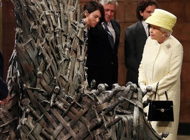 Королева Елизавета II внимательно разглядывает Железный трон на съемочной площадке «Игры престолов»