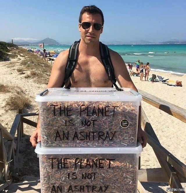 Парень собирает окурки на пляже под лозунгом "Планета не пепельница"