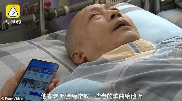 Ли Чжихуа слушает песню, которую включила ему его жена, в своей больничной палате. Хубэй, Китай, 21 августа