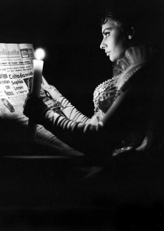 Софи Лорен, при свечах, читает о себе передовицу