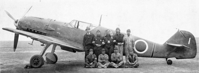 Японские и немецкие пилоты и авиаинженеры у истребителя Мессершмитт Bf.109E-4. Японская империя. 1941 год.