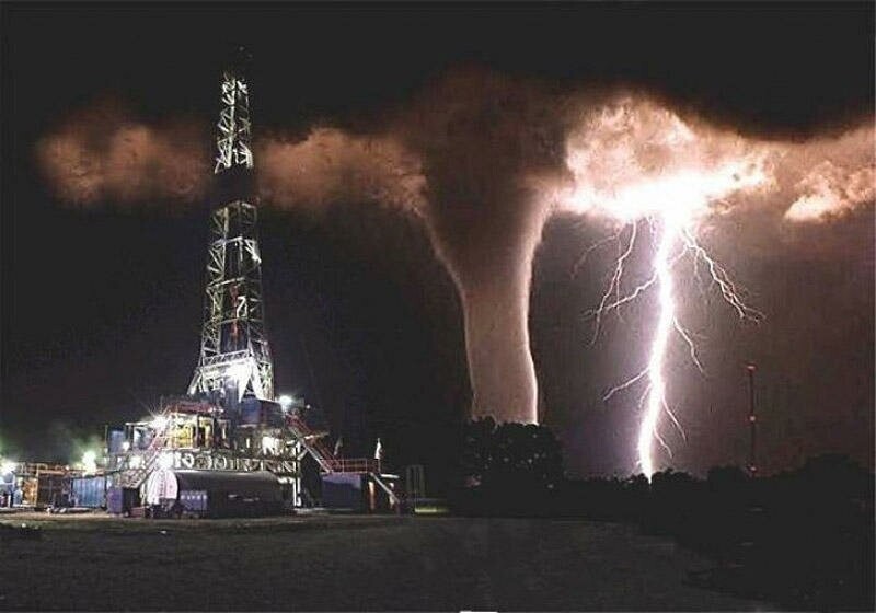 Нефтяная вышка на фоне торнадо и молнии.