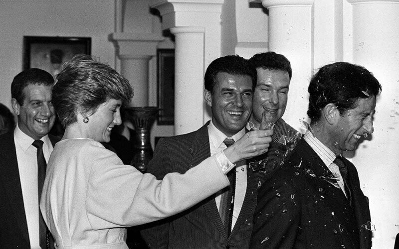 Принцесса Диана разбивает фальшивую бутылку на голове принца Чарльза во время посещения студии «Пайнвуд», 1986 год.