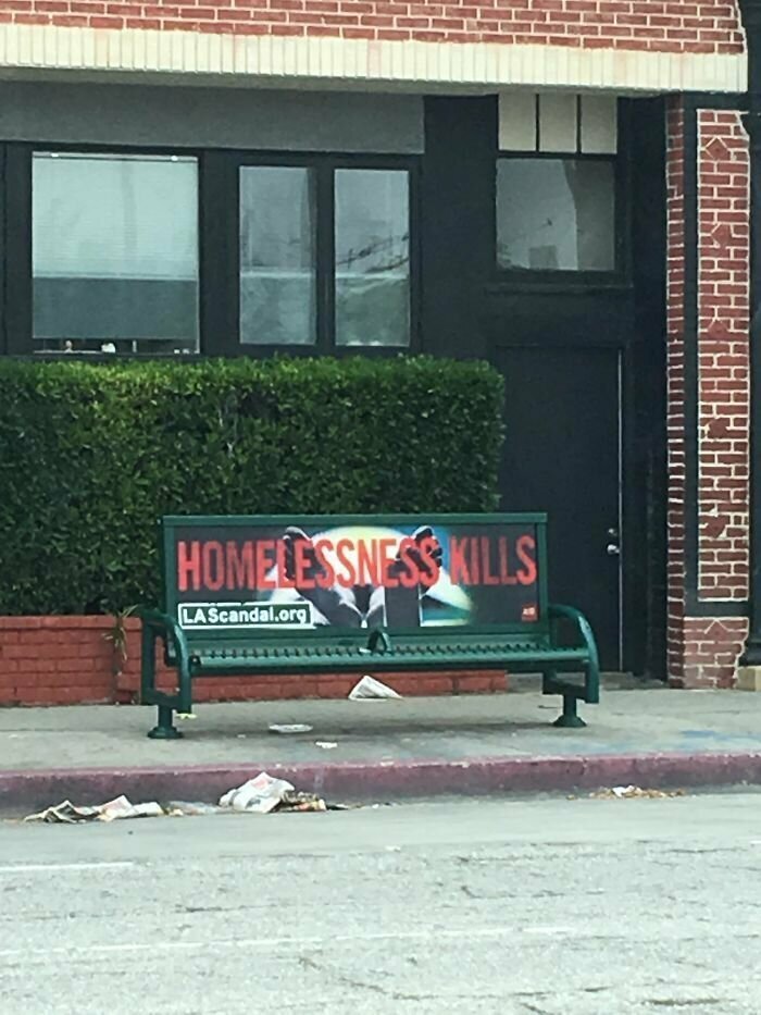 "Бездомность убивает" - гласит социальная реклама на скамейке, также оборудованной конструкцией против спящих на лавках бродяг