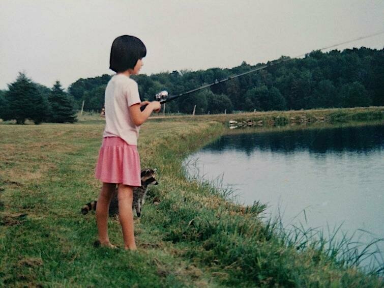 Девочка со своим ручным енотом на рыбалке, 1980-е