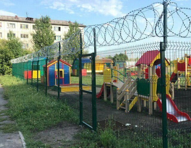 Детская площадка за колючкой и забором