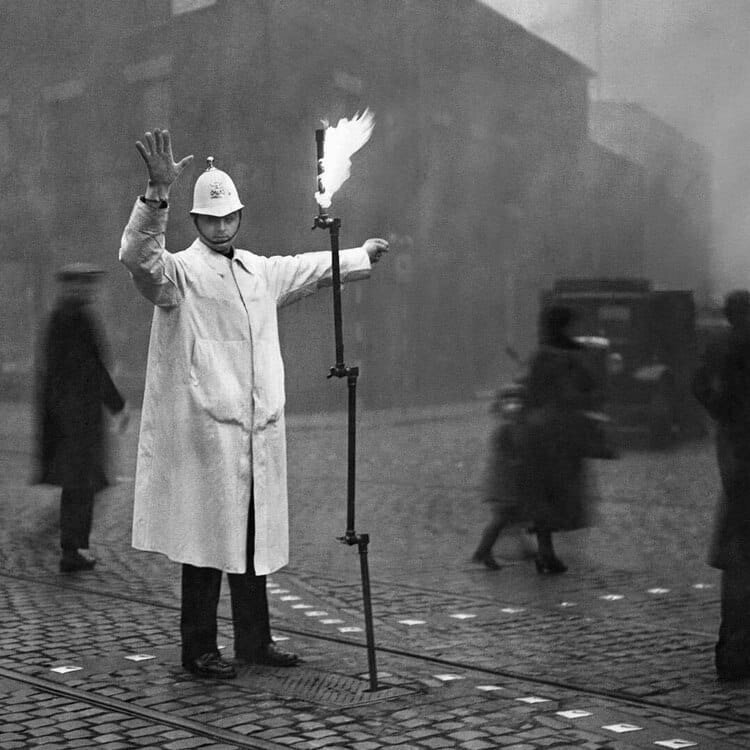  Регулировщик движения во время тумана использует в своей работе складное осветительное устройство, горящее от магистрального газа. Лондон, ноябрь 1935 года. 