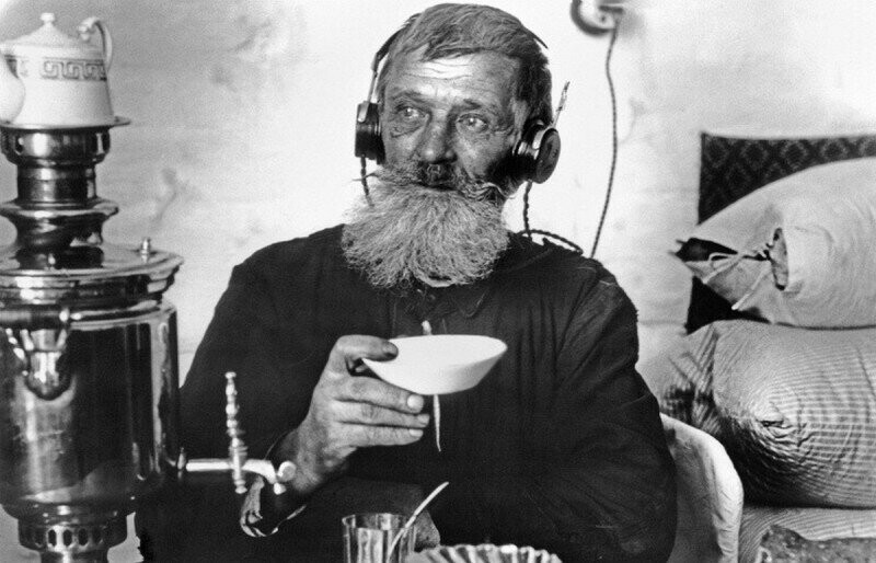Рабочий спичечной фабрики "Сибирь" пьет чай за прослушиванием радио. Томск,1928 г.