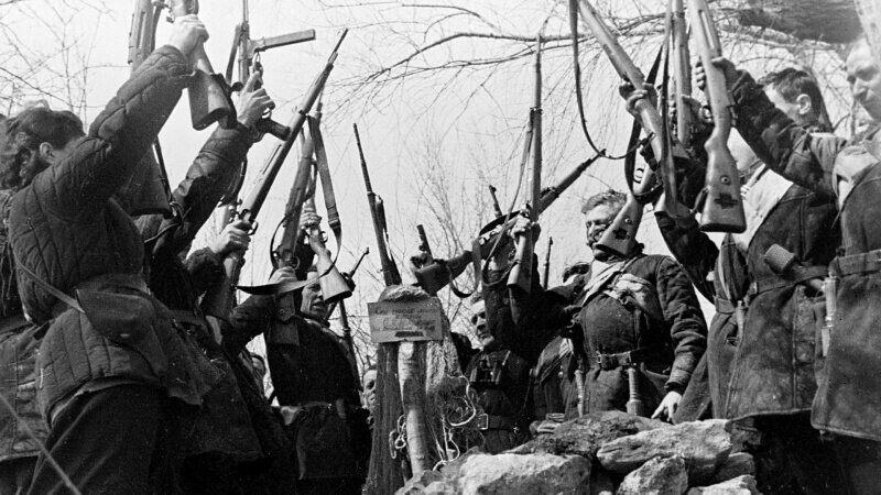 Советские партизаны клянутся отомстить за убитого товарища, стоя у его могилы