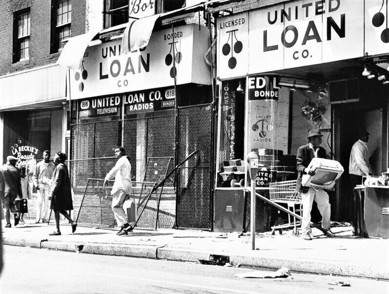 Возмущенный убийством Мартина Лютера Кинга гражданин в знак протеста выносит из магазина телевизор. Апрель 1968 года. 