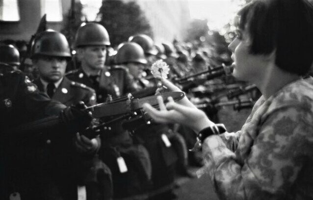 Семнадцатилетняя Джен Роуз Казмир дарит цветок враждебно настроенным солдатам во время митинга за мир в Пентагоне, 1967 год. 