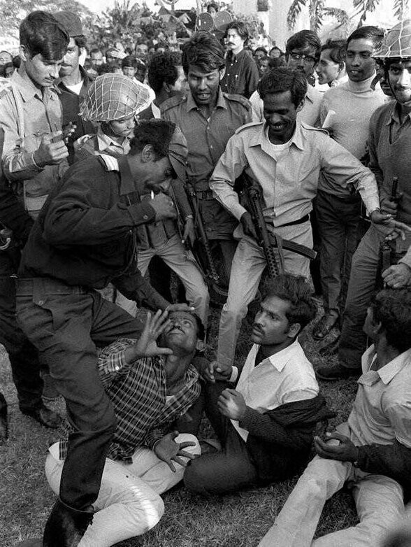 Лидер партизан из Бангладеш в Дакке избивает мужчину, подозреваемого в сотрудничестве с пакистанскими ополченцами, которых обвиняли в мародерстве, убийствах и изнасилованиях во время гражданской войны. 