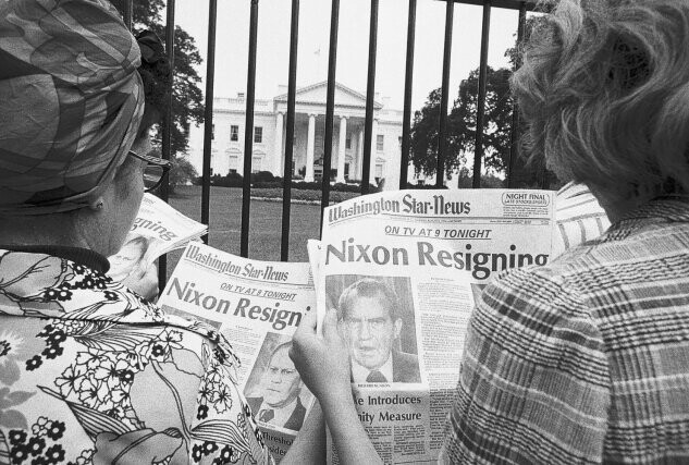 Жители США на фоне Белого дома читают статью об отставке президента.