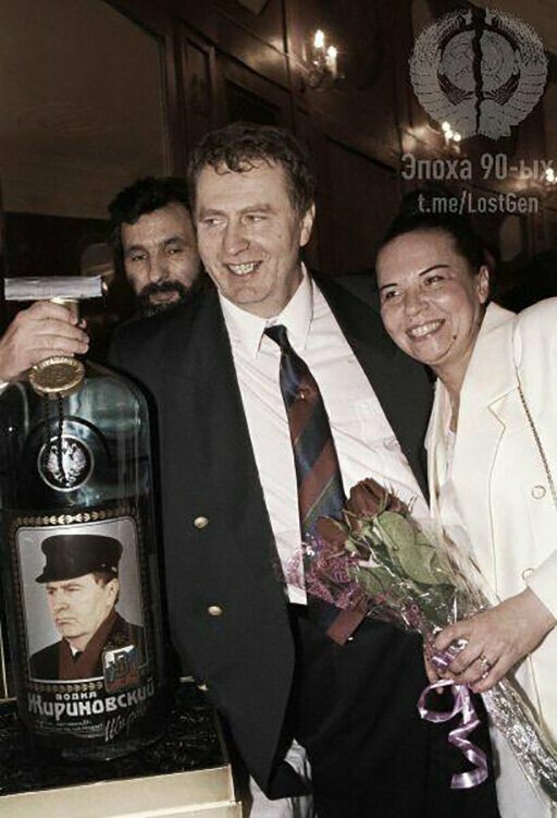 Владимир Жириновский с женой и большой бутылкой водки "Жириновский" подаренной ему на день рождения, 1994 год. 
