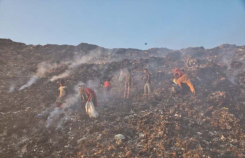 Бангладешские дети просеивают горящие груды мусора, чтобы найти что-то ценное для продажи