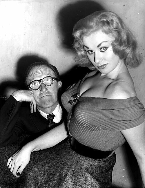Гламурная модель и актриса Сабрина сидят на коленях у комика Артура Аски. 1955 