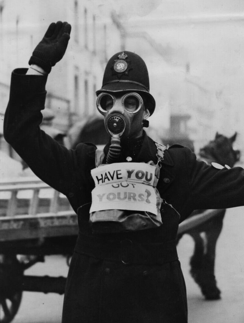 Глостерширский дорожный полицейский носит знак, напоминающий общественности о необходимости надевать противогазы, март 1941 г.