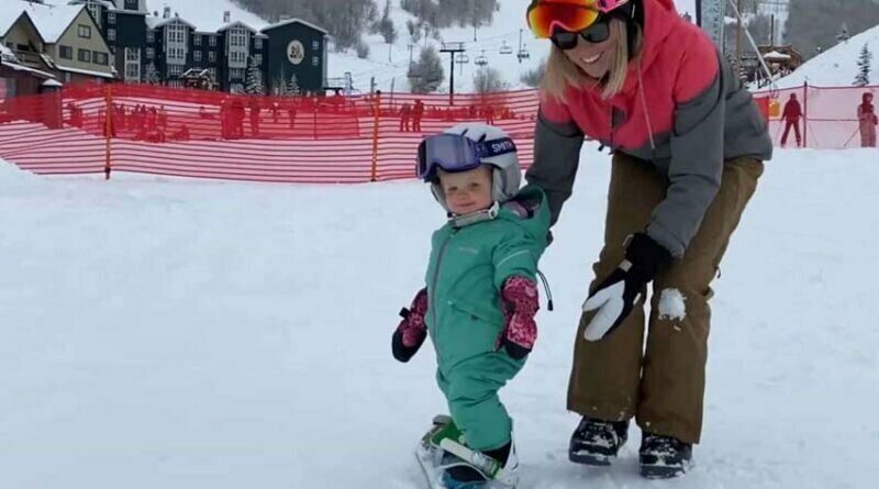 Годовалая девочка прекрасно стоит на сноуборде