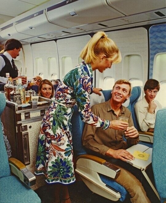 Стюардесса предлагает пассажиру стаканюку вискаря, и желает счастливого полета, на Qantas 747 в 1983 году 