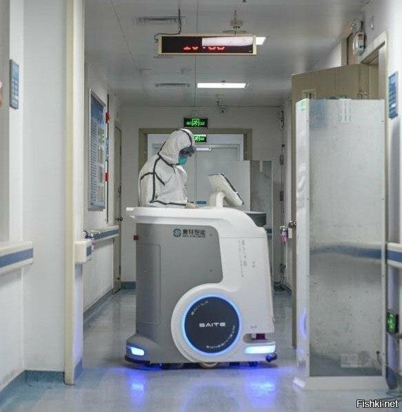 Человек с роботом в отделении инфекционных заболеваний в больнице провинции Г...
