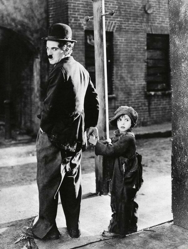 Чарли Чаплин во время съемок своего первого полнометражного фильма «Малыш» с Джеки Куганом, одним из первых детских актеров в истории кино. США, 1921