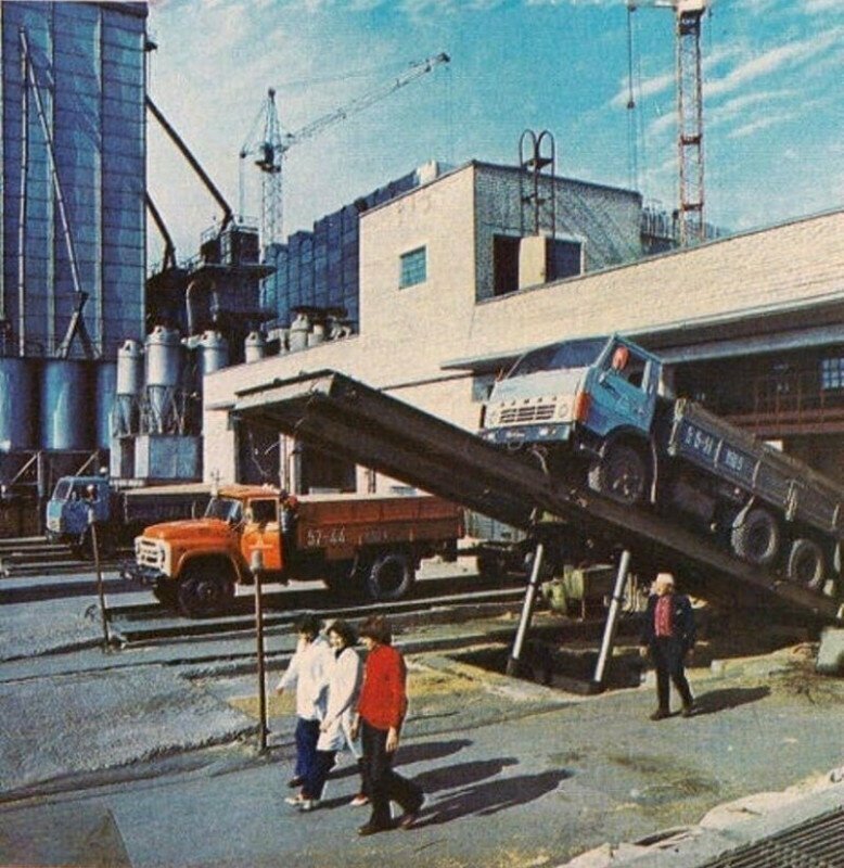 Процесс разгрузки бортовых грузовиков с зерном на территории одного из крупных элеваторов. СССР, 1980-е