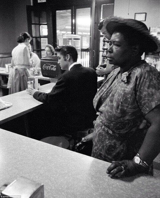 Элвис Пресли ожидает яйца с беконом в то время, пока чернокожая женщина ждет свой сендвич. 