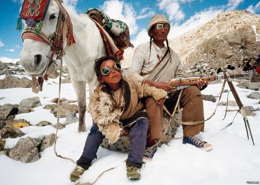 Отец и сын, жители Тибета, поднимаются на гору Кайлас