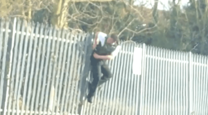 Беспомощный полицейский повис на заборе