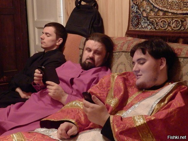 Католический священник показывает своему коллеге, как смотреть в интернете го...