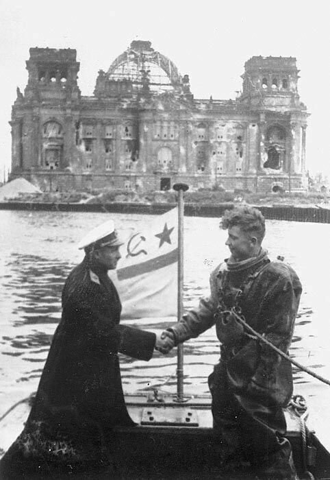 Контр-адмирал советского флота Крылов благодарит водолаза за расчистку реки Шпрее в центре Берлина  на фоне Рейхстага, в 1945 год