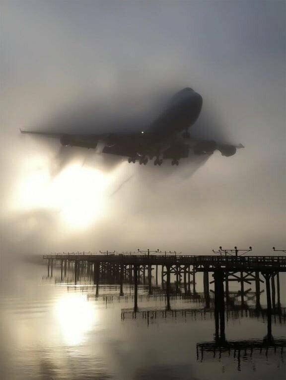Боинг 747 летит сквозь утренний туман