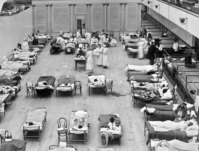 Медсестры-добровольцы Красного Креста ухаживают за больными в зале муниципального совета Окленда, переоборудованном в госпиталь