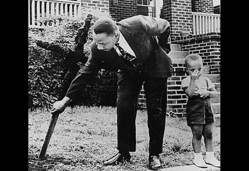 Мартин Лютер Кинг убирает на своём газоне после подпала в 1960 году.