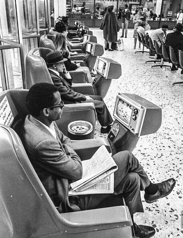 В ожидании транспорта на автобусной станции Greyhound в Лос-Анджелесе пассажиры смотрят телевизоры, включающиеся с помощью монеток, 1969 год