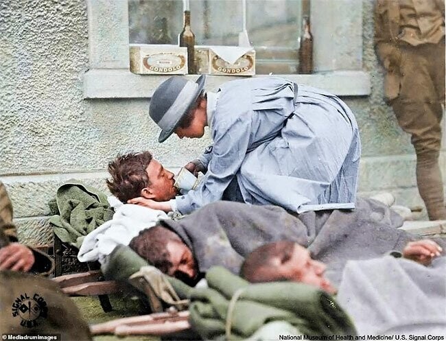 Медсестра Американского Красного Креста помогает раненым солдатам в Монмирае, Франция, 31 мая 1918 года