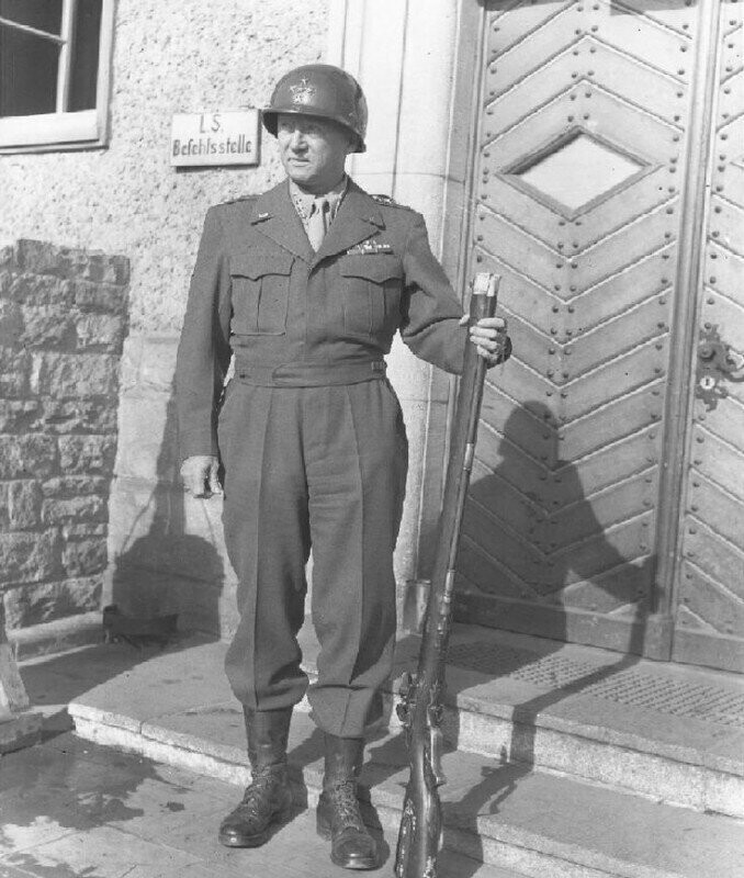 Американский генерал Джордж Паттон позирует с немецким кремневым ружьём после захвата Франкфурта. 29 марта 1945 года. Германия.