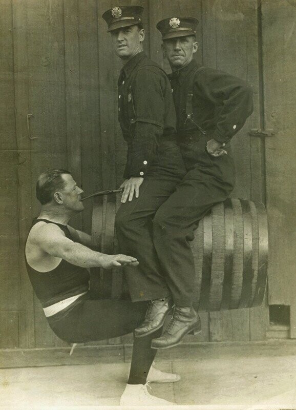 Гарри Ф. Гриффин, силач из пожарной охраны Лос-Анджелеса, держит зубами двух коллег. 1914