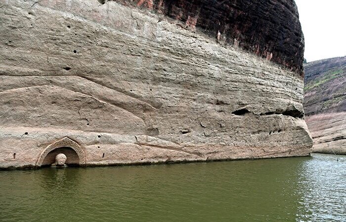 10. "После того, как строительная компания осушила водоем на 3 метра, была найдена 600-летняя статуя Будды, вырезанная в скале"