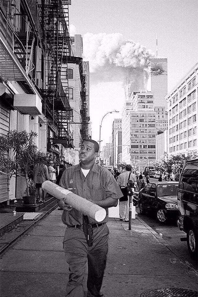 Человек идёт доставить посылку, не осознавая масштаба трагедии. Нью-Йорк, 11 сентября, 2001 г.