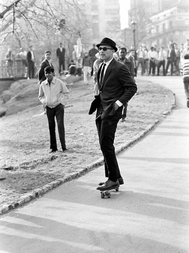 Мужчина в костюме и темных очках едет на скейтборде в Центральном парке (1965)