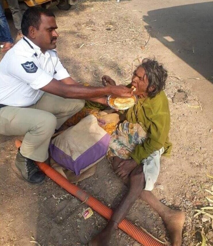 15. В Индии сотрудник полиции кормит пожилую бездомную