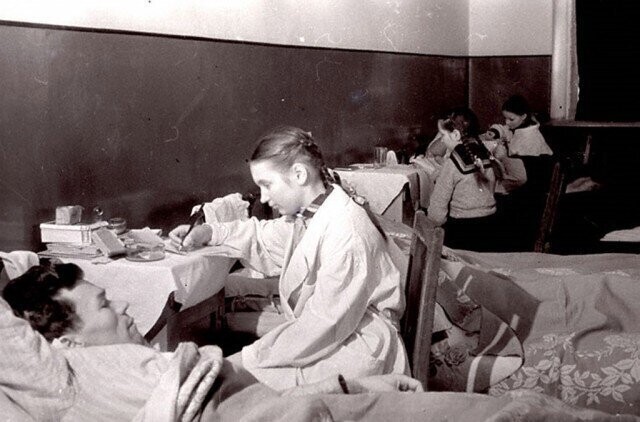 Учащиеся школы № 6 г.Калинина пишут письма домой под диктовку раненых бойцов, находящихся на излечении в госпитале. 1943 г. Калинин.