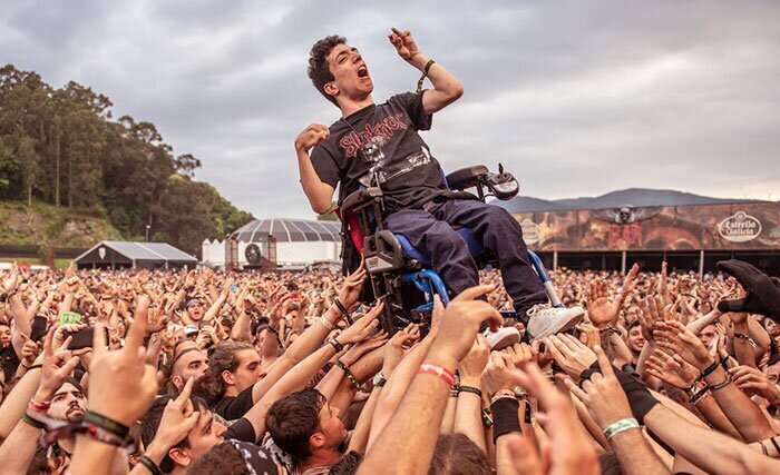 17. "Фаната рок-музыки в инвалидном кресле подняли на руках, чтобы он увидел любимых музыкантов"