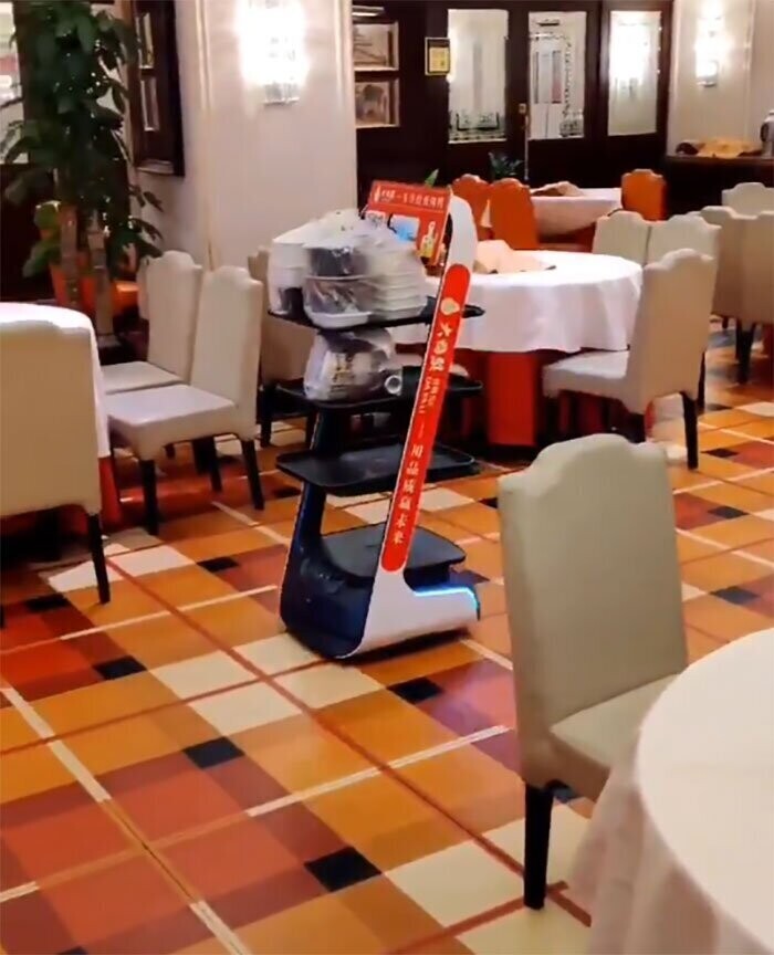 Робот везет еду для посетителей ресторана, которые заказали блюда навынос, Пекин