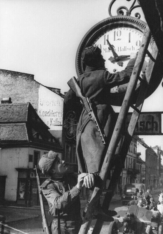 Сержант А.М. Ярушин и гвардии сержант И.К. Роговский переводят часы на московское время в немецком городе Ноймаркт, 1945 год. Германия.