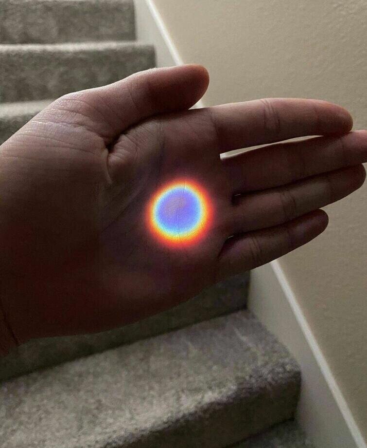 Идеальная круглая радуга, получившаяся благодаря солнечному свету, прошедшему через дверной глазок