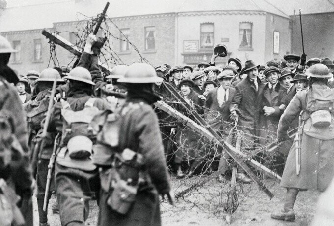 Толпа поддерживающая партию Sinn Fein выступает против британских солдат перед баррикадами в Дублине. Ирландия, 30 апреля 1920 года.