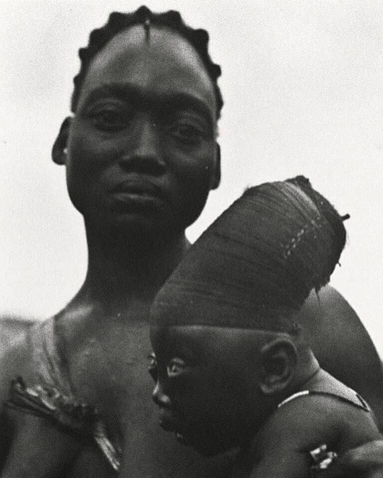 Мать из племени мангбету держит своего сына, которому удлиняют череп согласно традициям. Конго, 1950 год.
